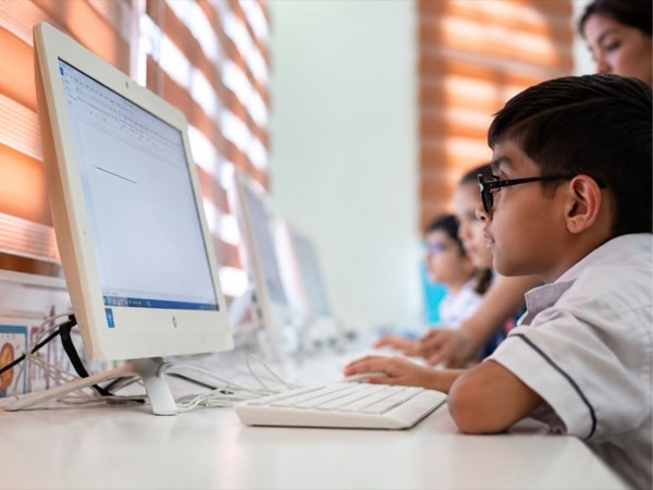 A pupil writing at their desk